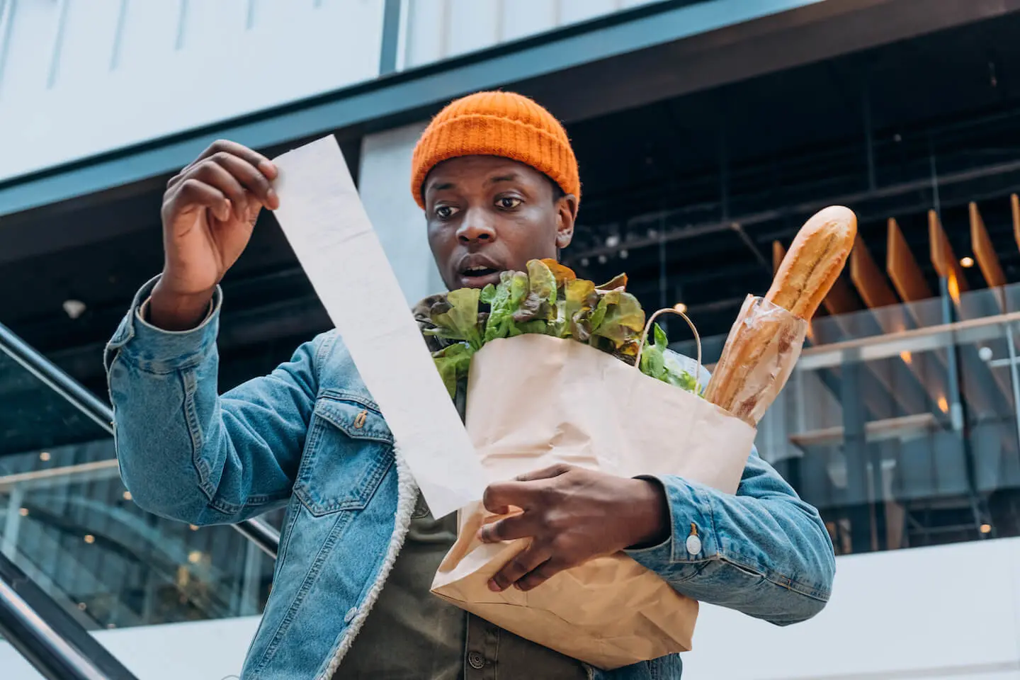 When will inflation go down: shocked man looking at a receipt