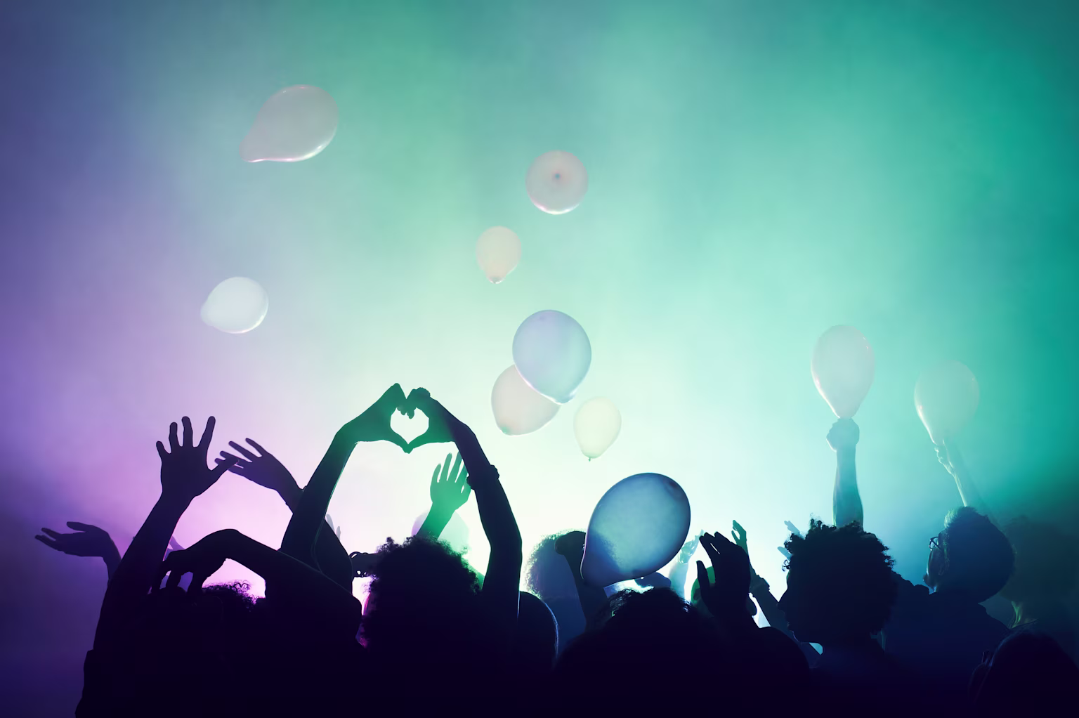 Group of people at celebration with balloons.
