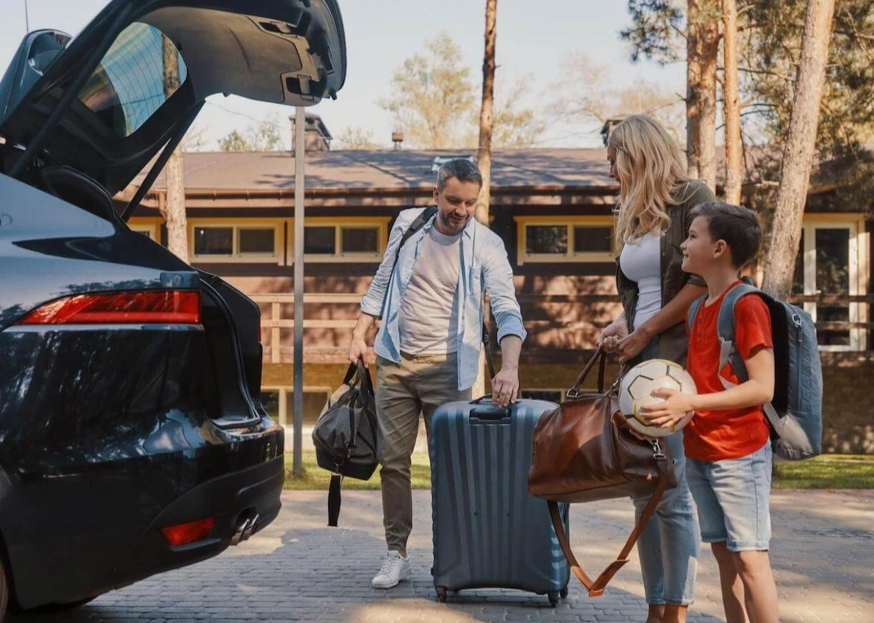 Budget family travel: family putting their things into a car
