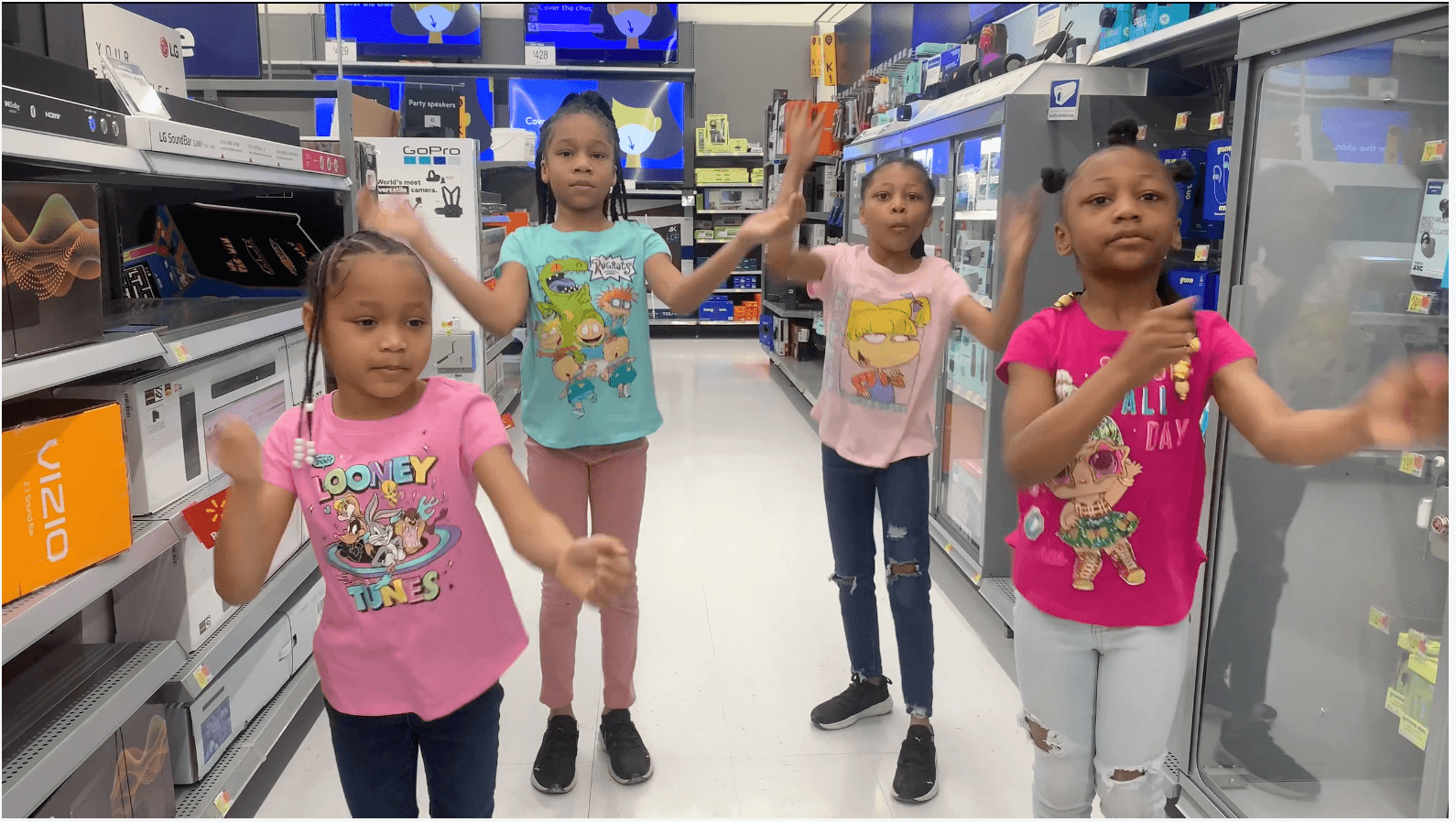 young girls dancing in the electronic aisle of a store