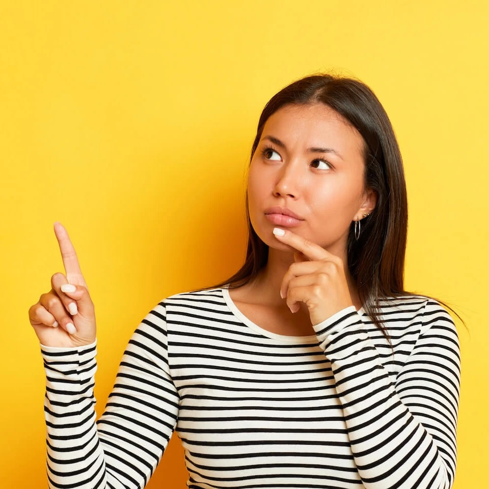 Woman thinking while pointing her finger upwards