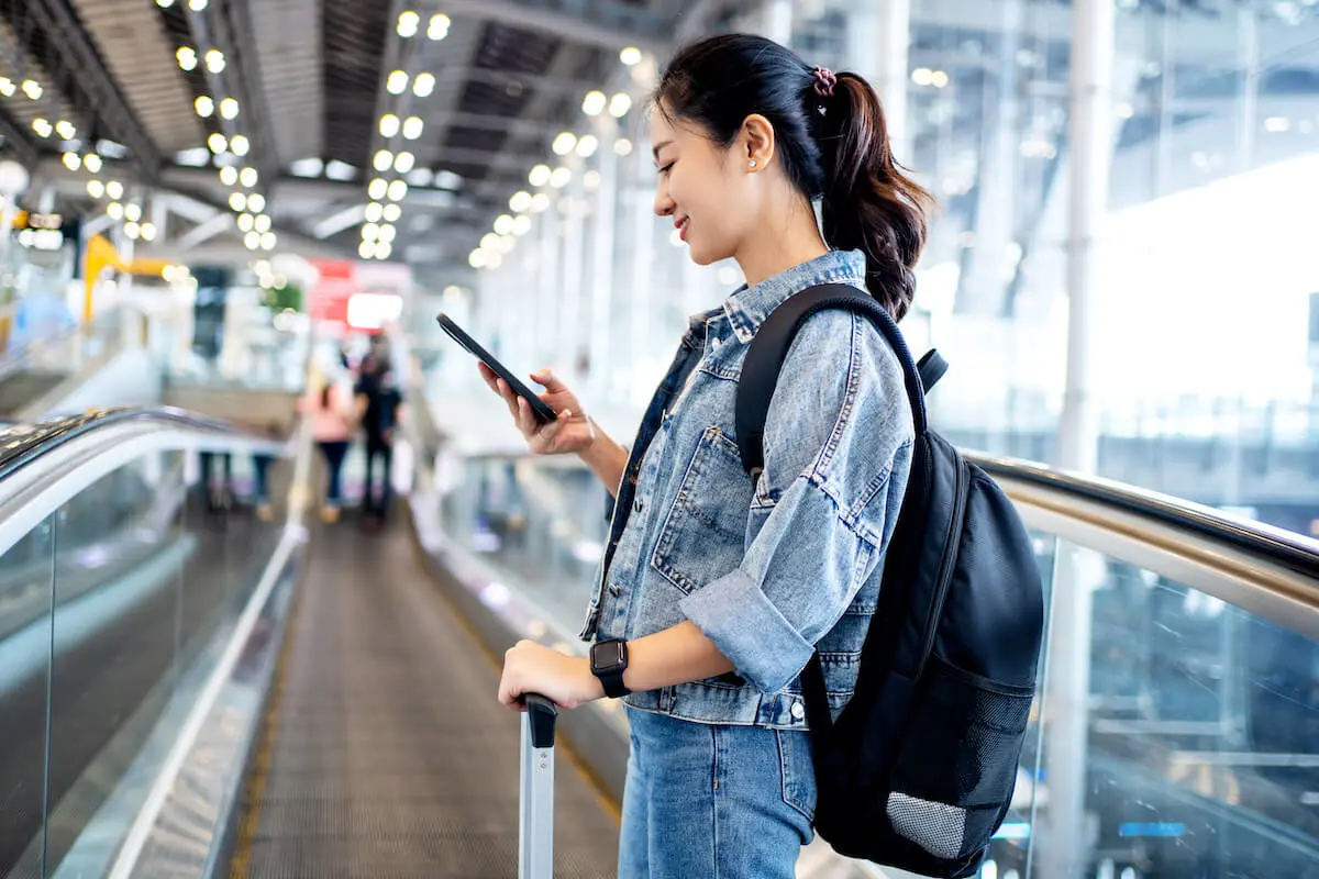 Woman using her phone at an airport