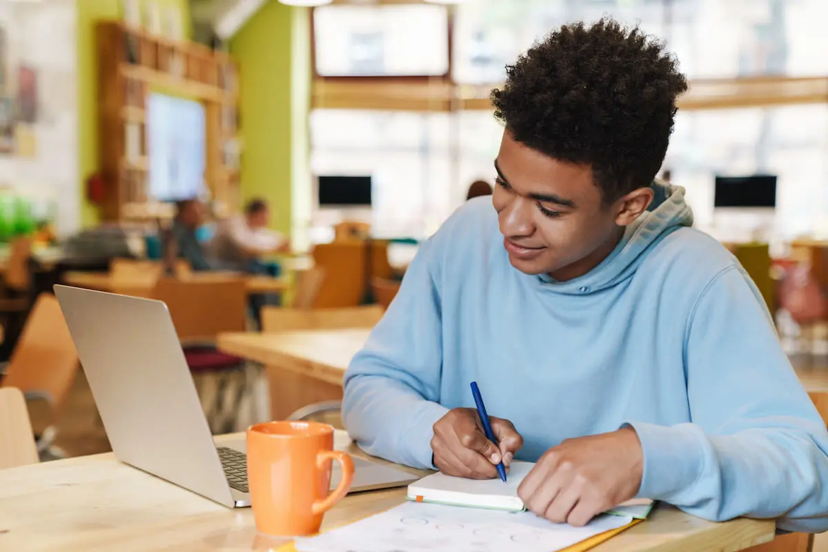Teenager noting down online jobs for teens that he can do