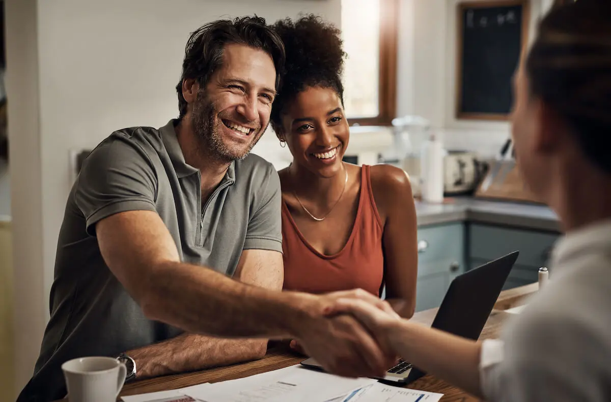 Couple shaking hands with advisor and discussing financial plans for the new year 2023