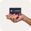 Woman's hand holding a Greenlight debit card
