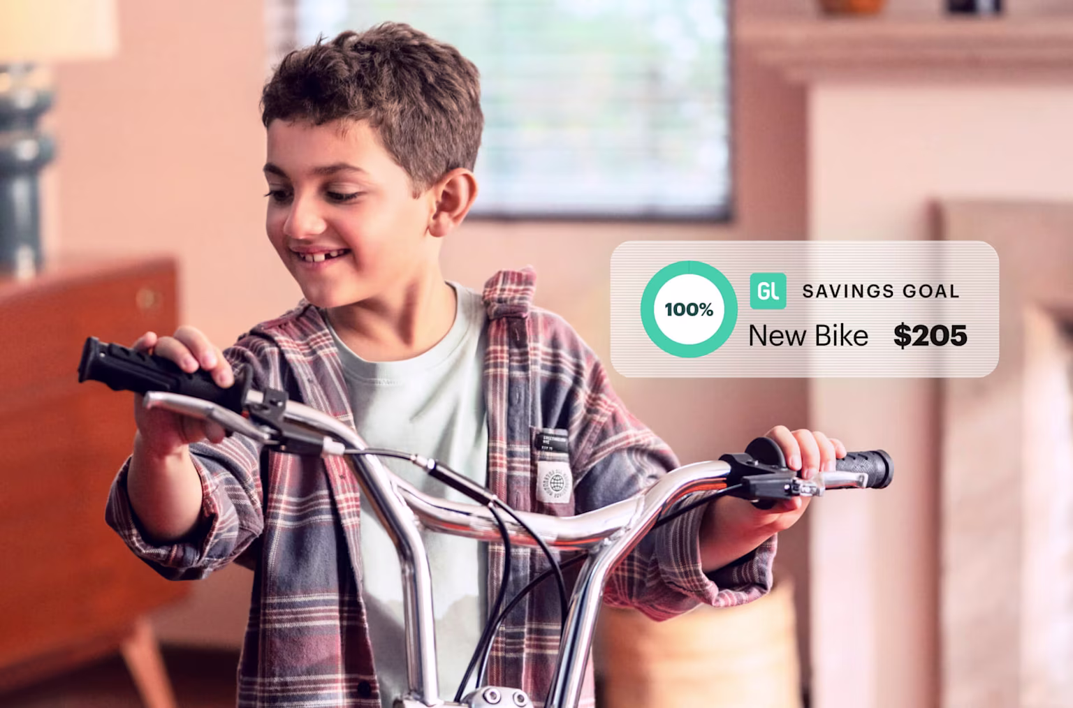 Young boy rides new bike inside after meeting his Savings Goal with the Greenlight money app for kids