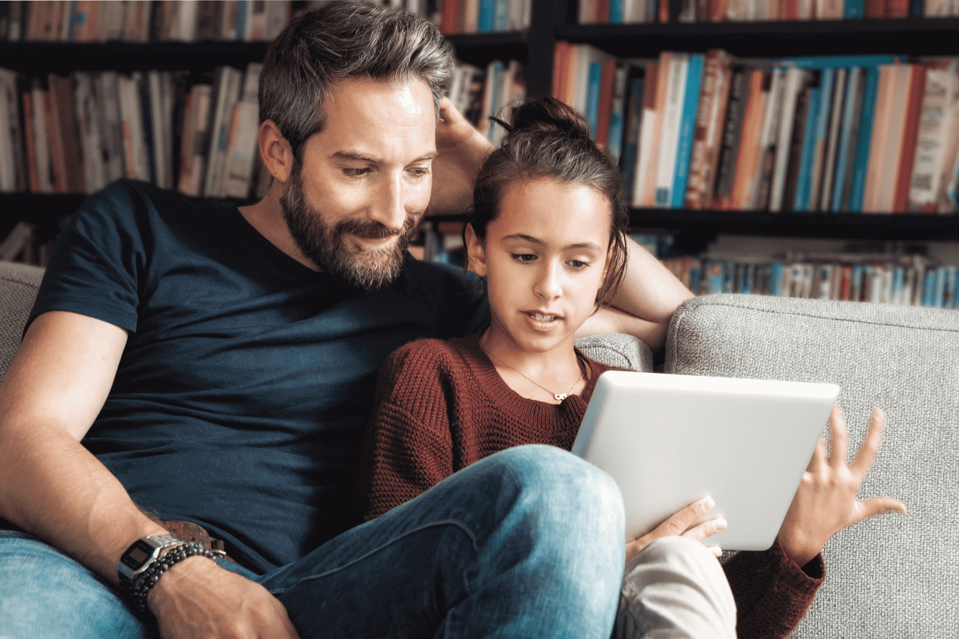 Young girl and father learning about stocks on tablet with Greenlight’s investing app