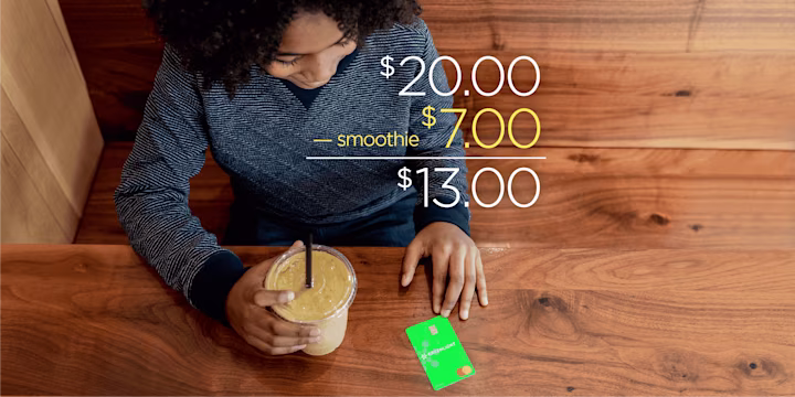 kid with a smoothie and greenlight debit card