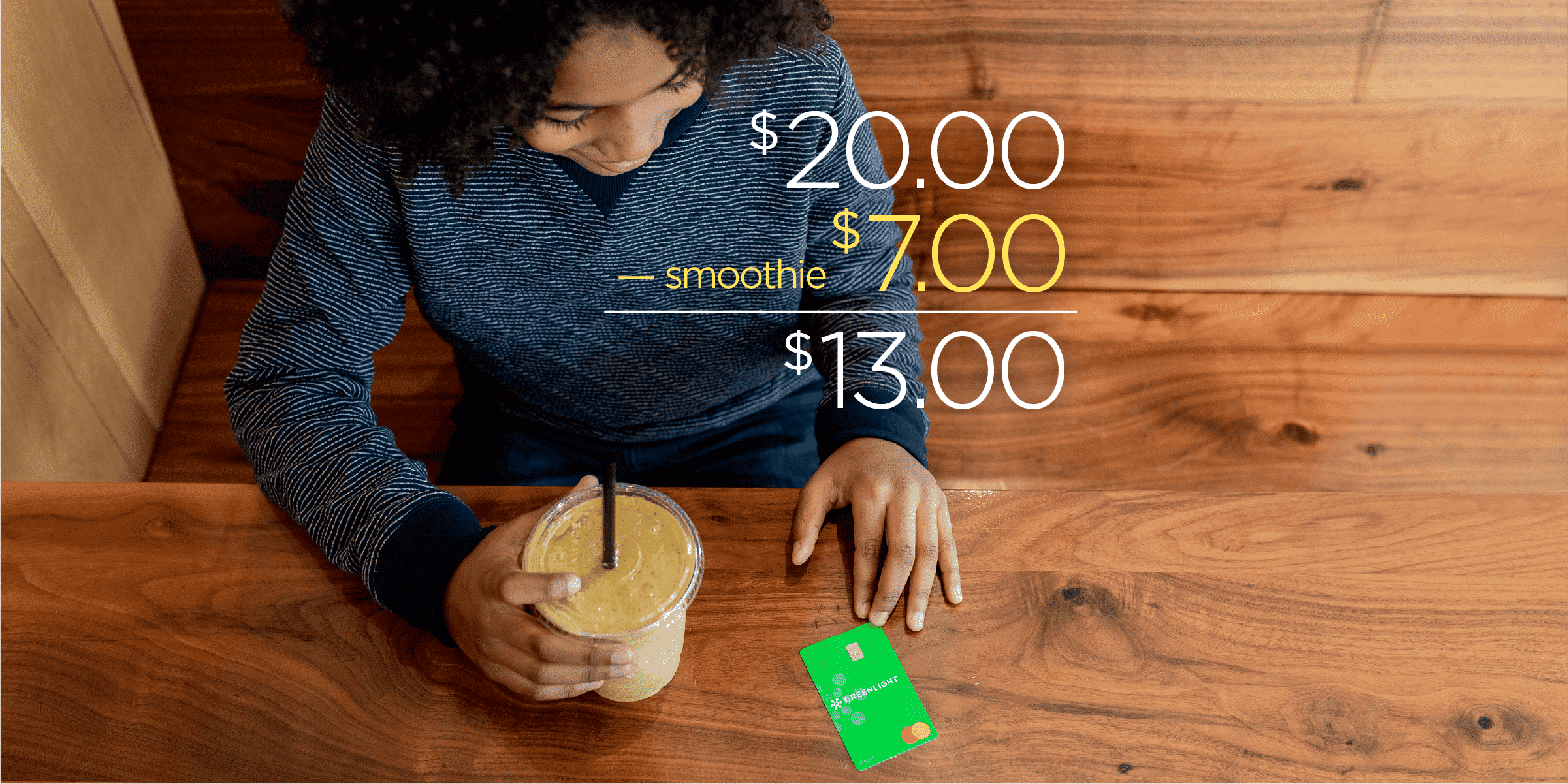 kid with a smoothie and greenlight debit card
