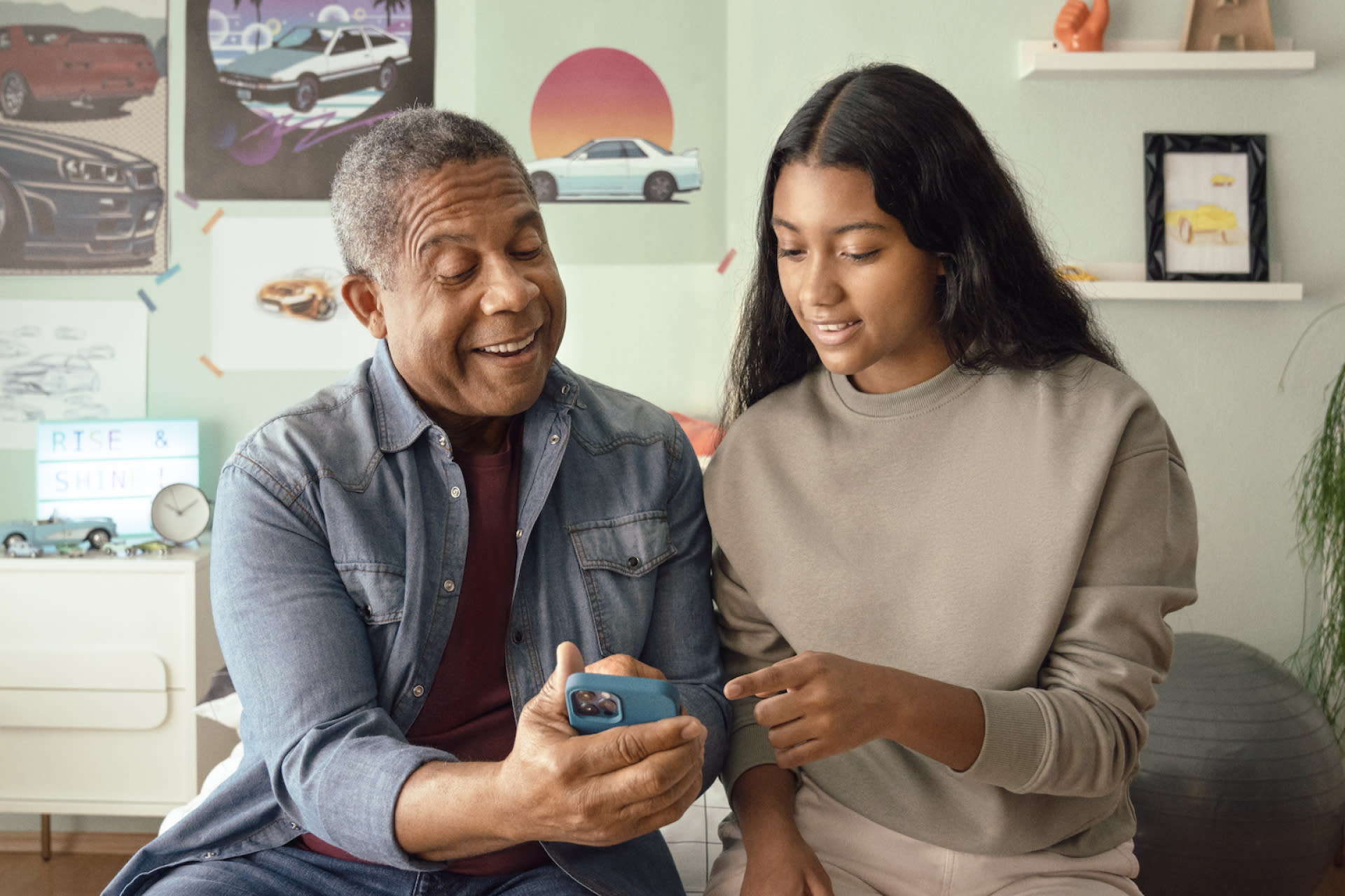 Greenlight father and daughter looking at app to invest for college costs and offset financial aid