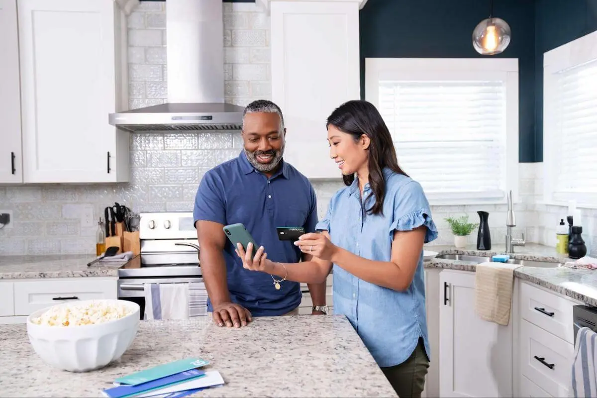 Parents looking at phone together in kitchen