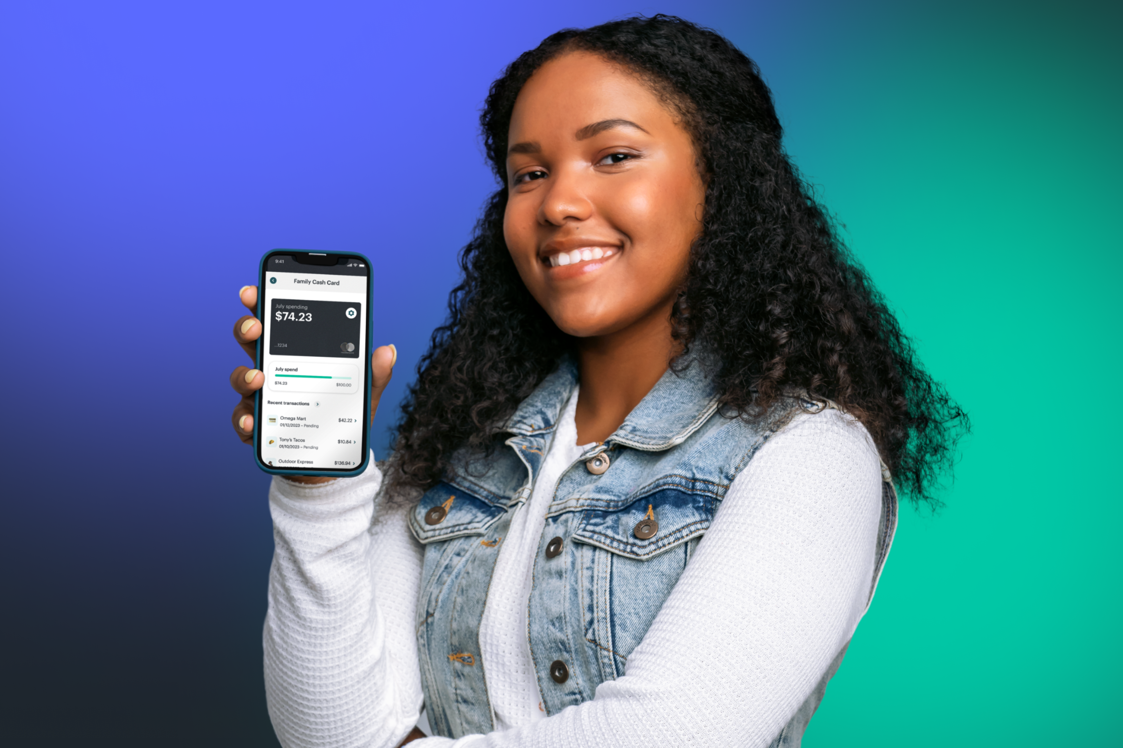 Teen girl showing mobile money app with Greenlight teen credit builder 