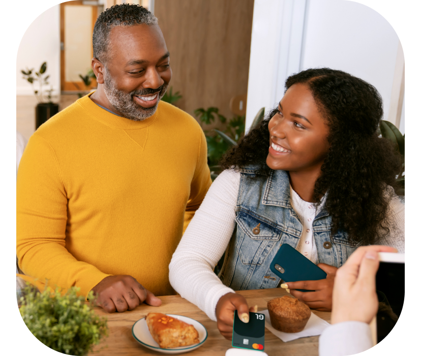 Father and daughter paying for food with Greenlight Debit Card for Teens