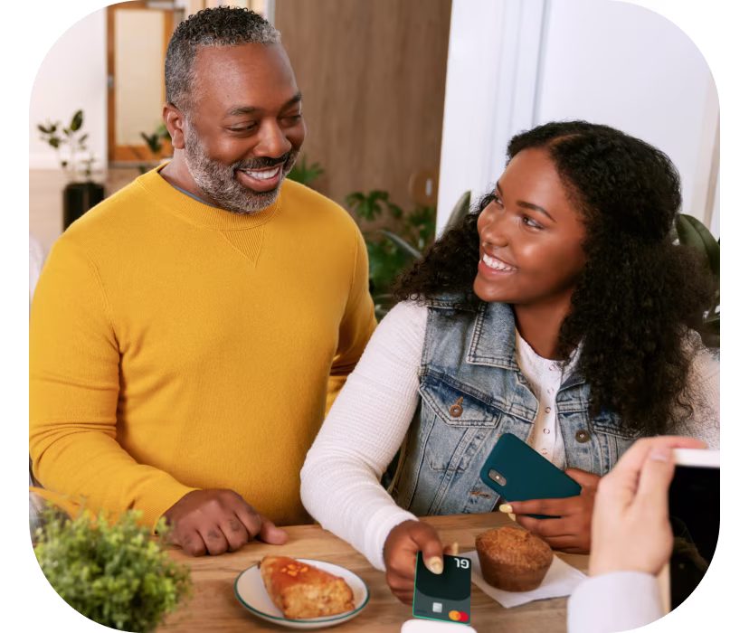 Father and daughter paying for food with Greenlight Debit Card for Teens