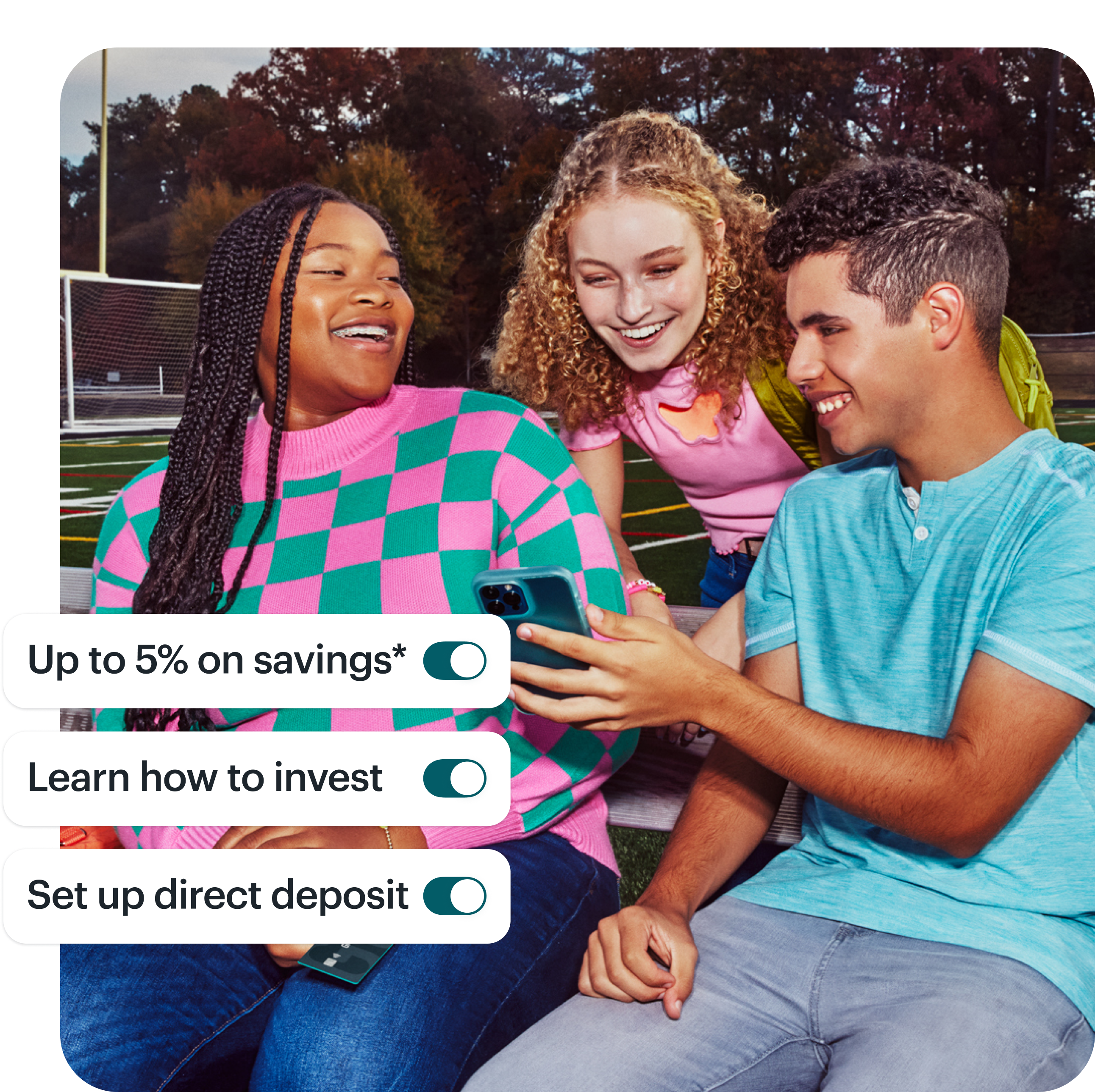 3 teens sit on bleachers and gather to look at one of their phones, smiling and natural. On top of the image are 3 toggles listing product features: "Up to 5% on savings," "learn how to invest," and "set up direct deposit."