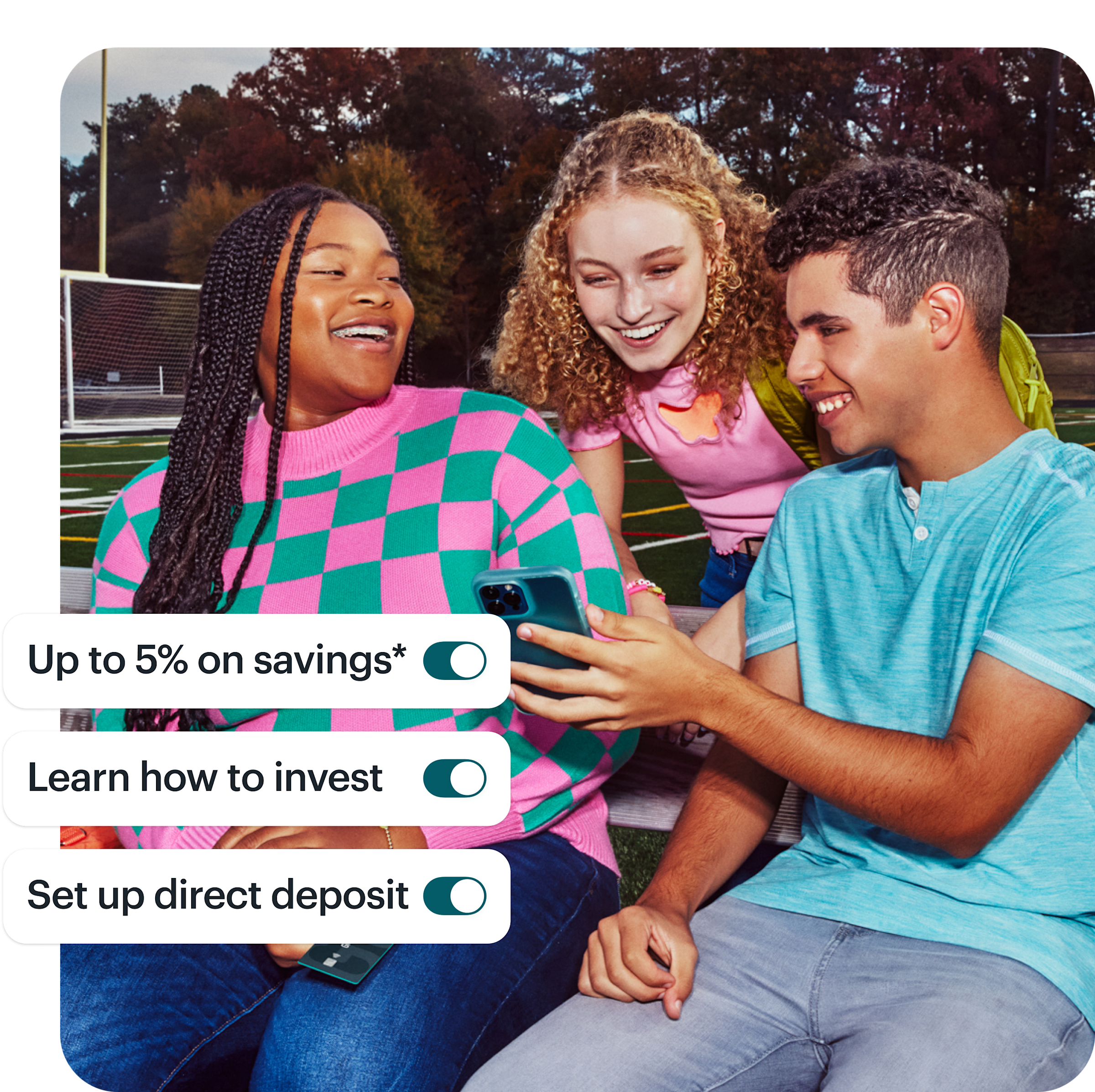 3 teens sit on bleachers and gather to look at one of their phones, smiling and natural. On top of the image are 3 toggles listing product features: "Up to 5% on savings," "learn how to invest," and "set up direct deposit."