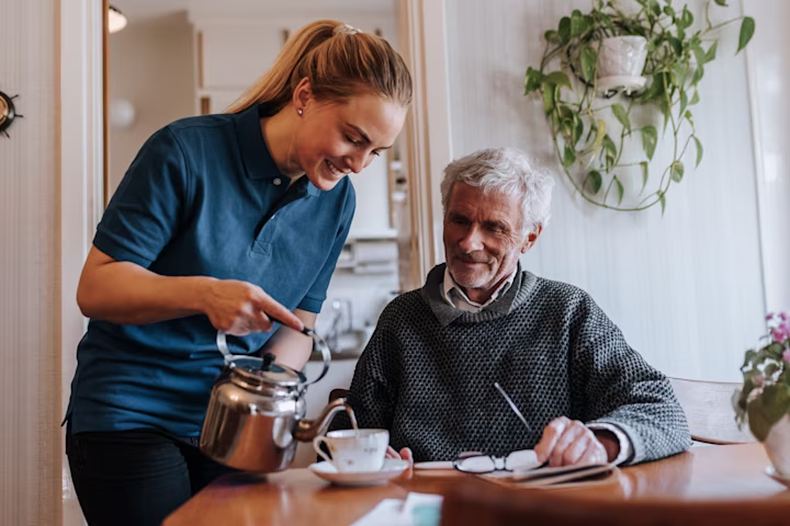 Woman pouring tea for senior citizen