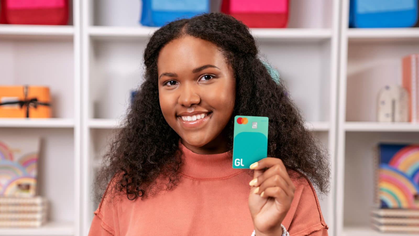 teenage girl holding a greenlight debit card