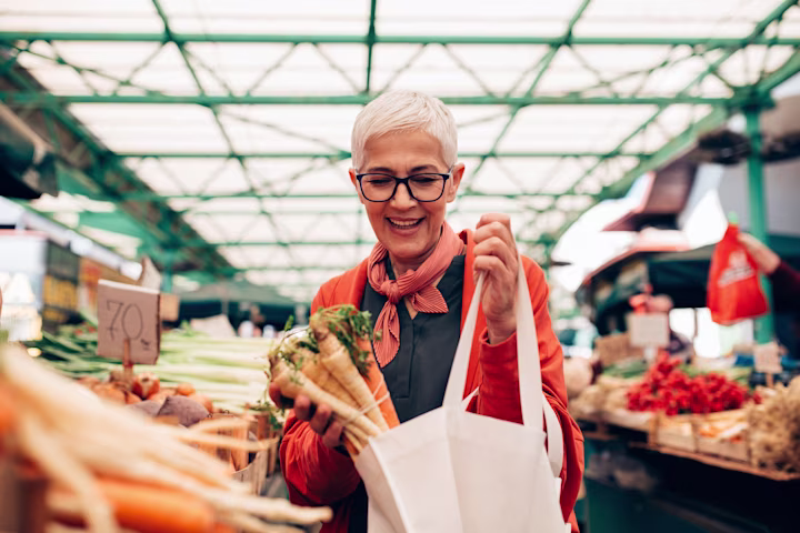 Woman shopping in produce section of grocery store.