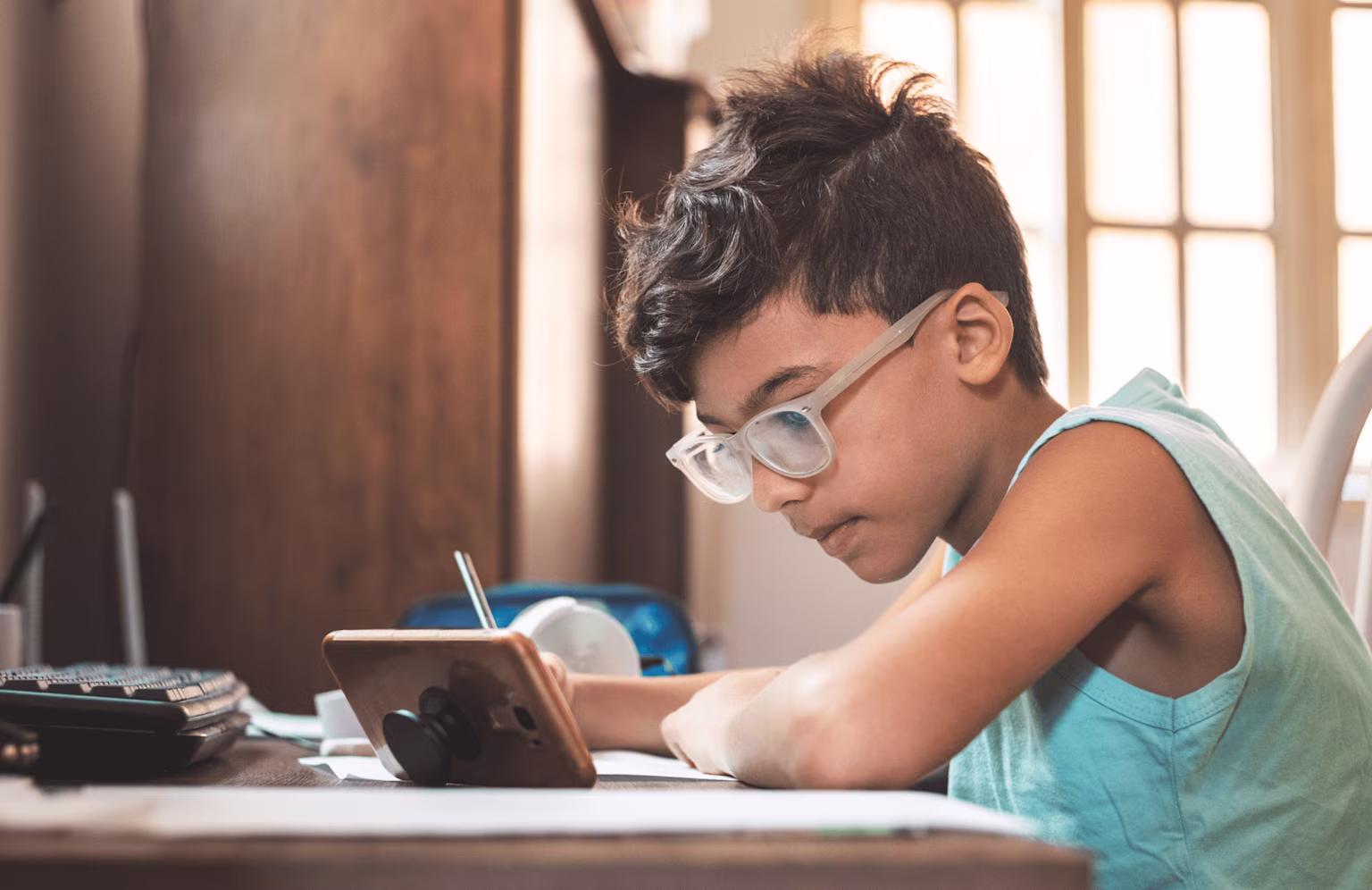 a young boy looking intently at his phone and investing