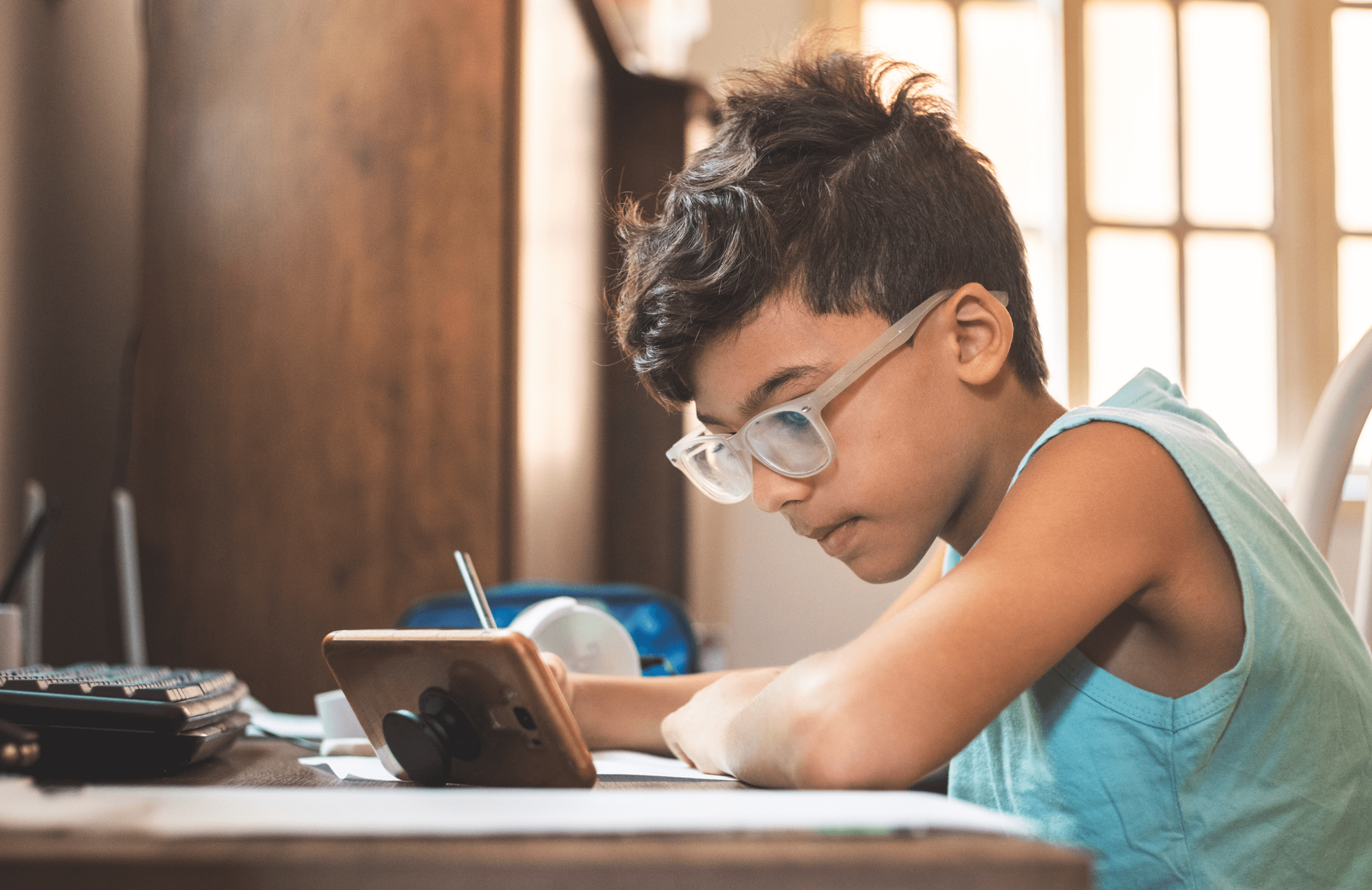 a young boy looking intently at his phone and investing