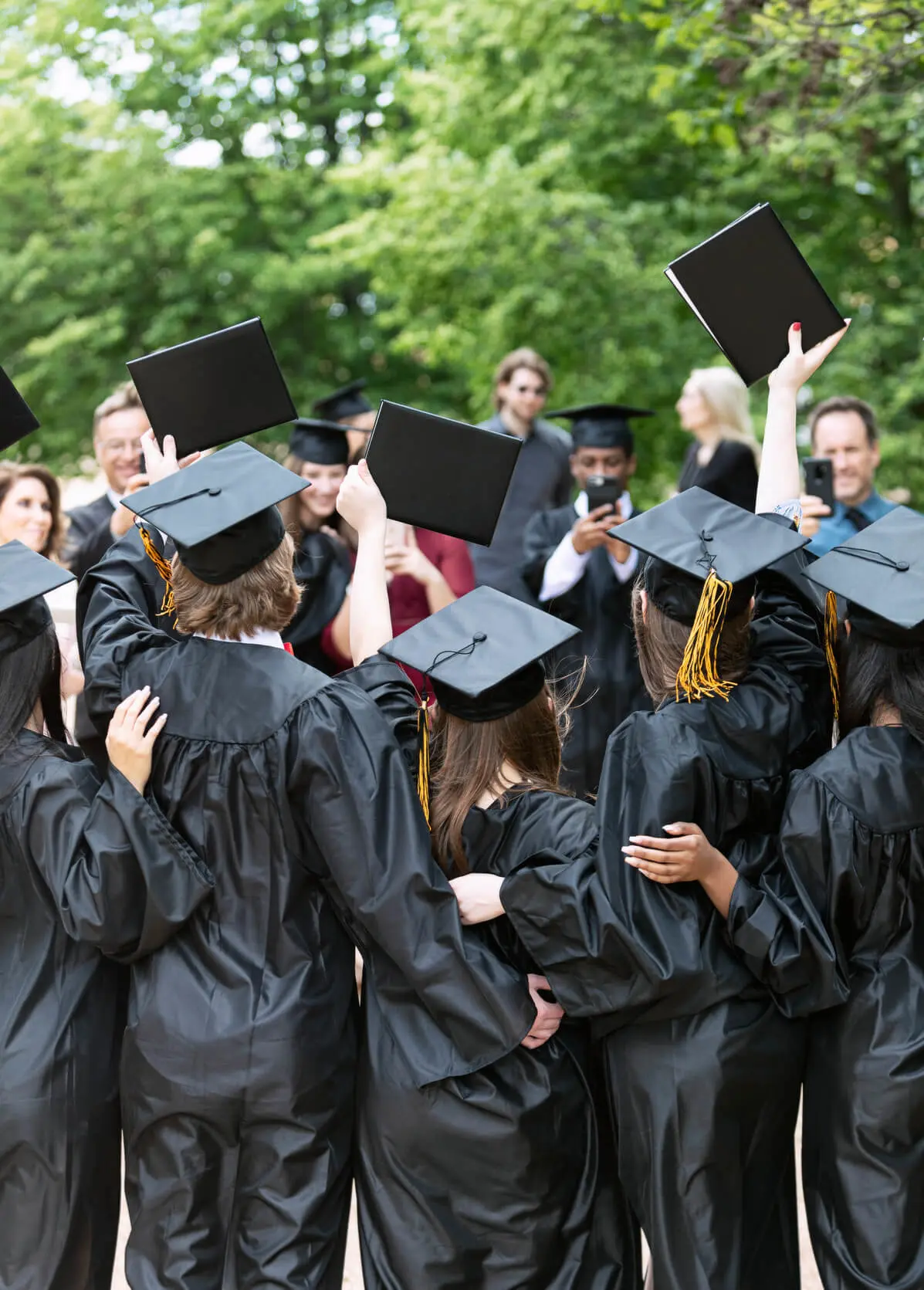 Graduates raising their diplomas