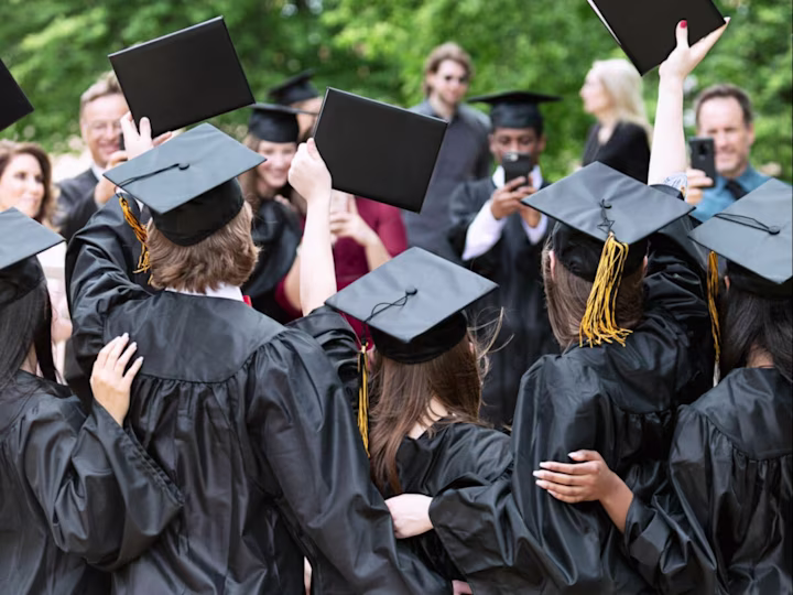 Graduates raising their diplomas