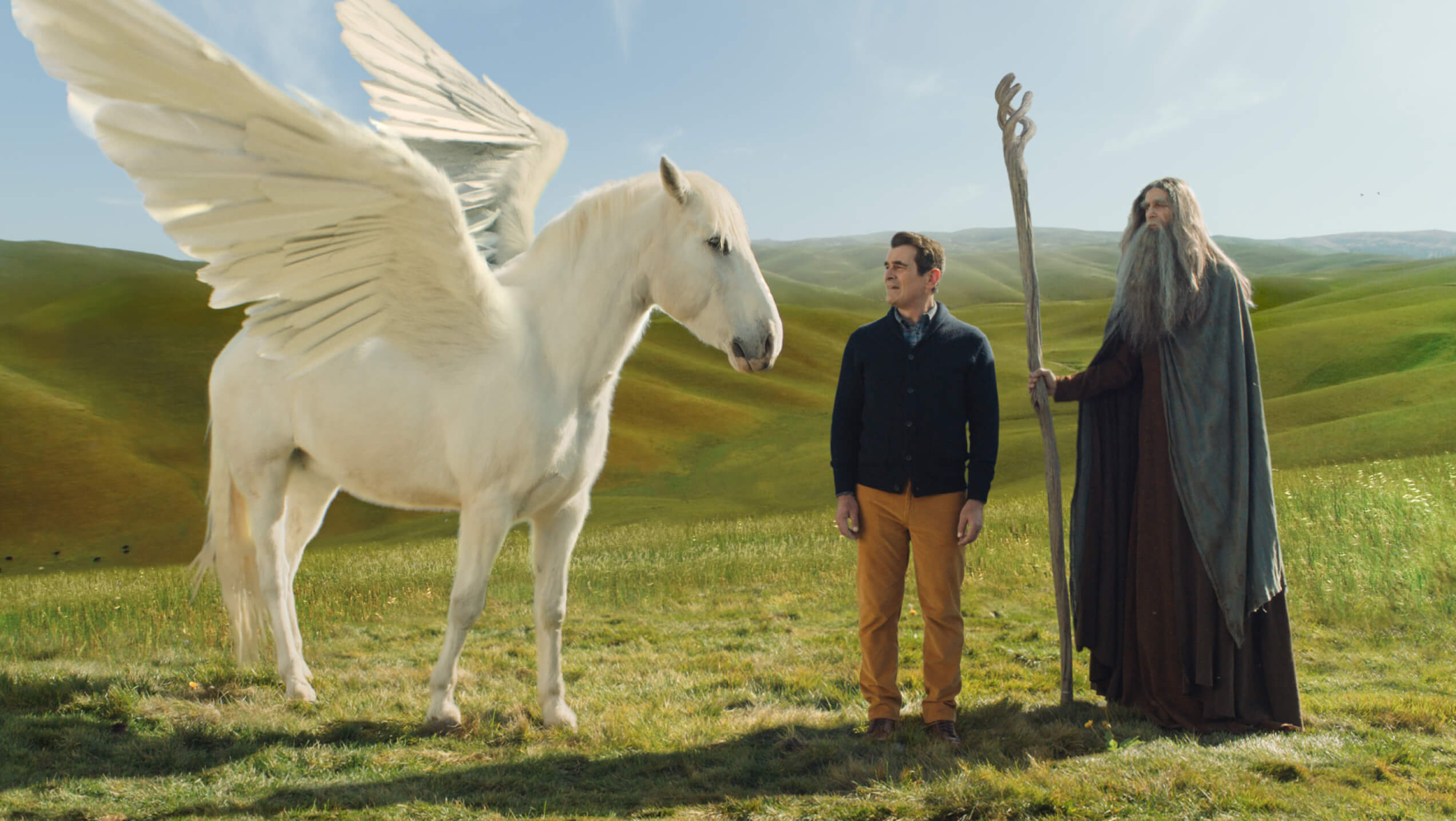 ty burrell standing next to a pegasus from a greenlight ad