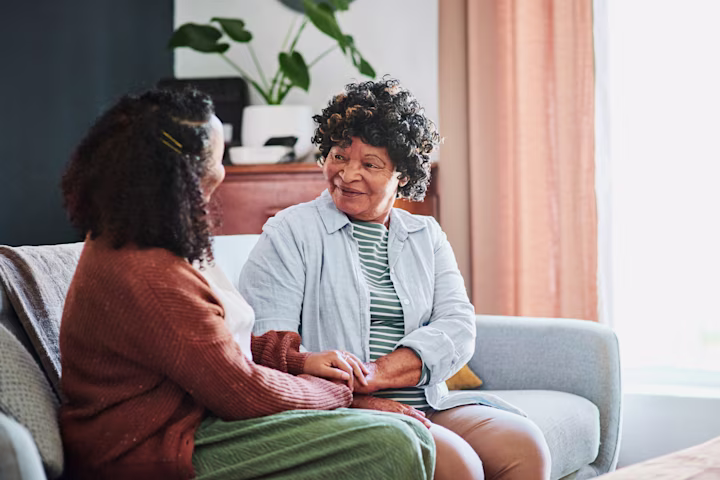 Elderly mother talking with daughter on couch