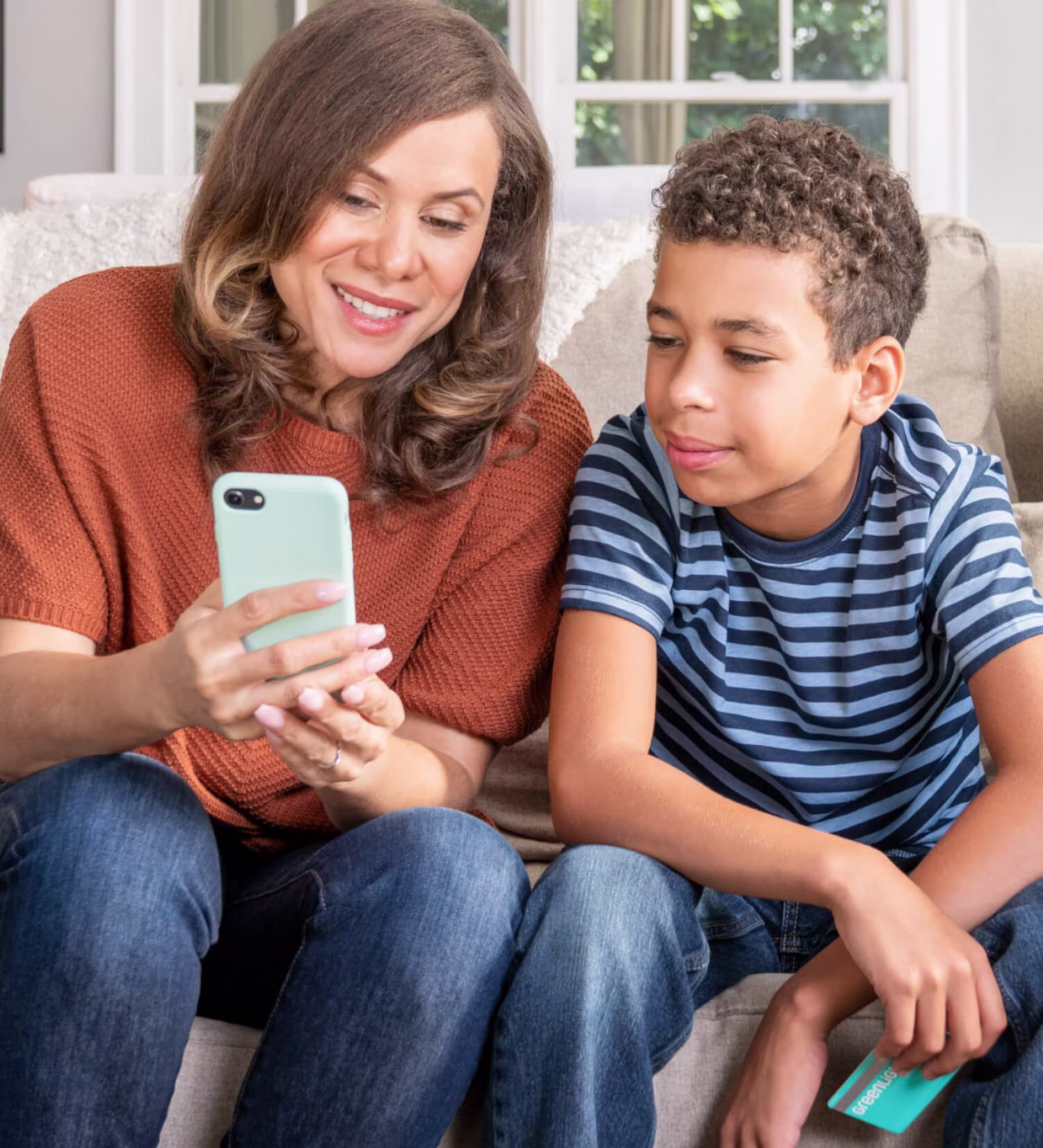 mother and her son holding his greenlight debit card
