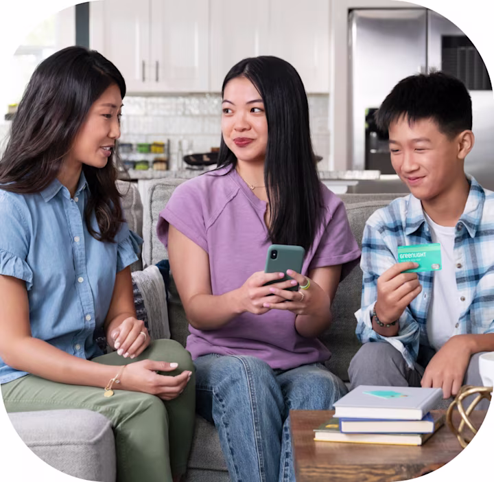 Mom and kids on the couch talking about the new Greenlight parent credit card with up to 3% cashback
