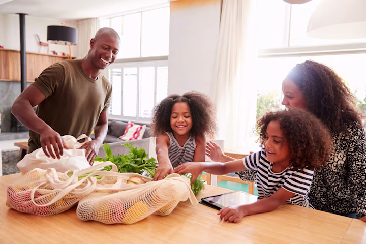 Save money on groceries: family unpacking fruits and vegetables