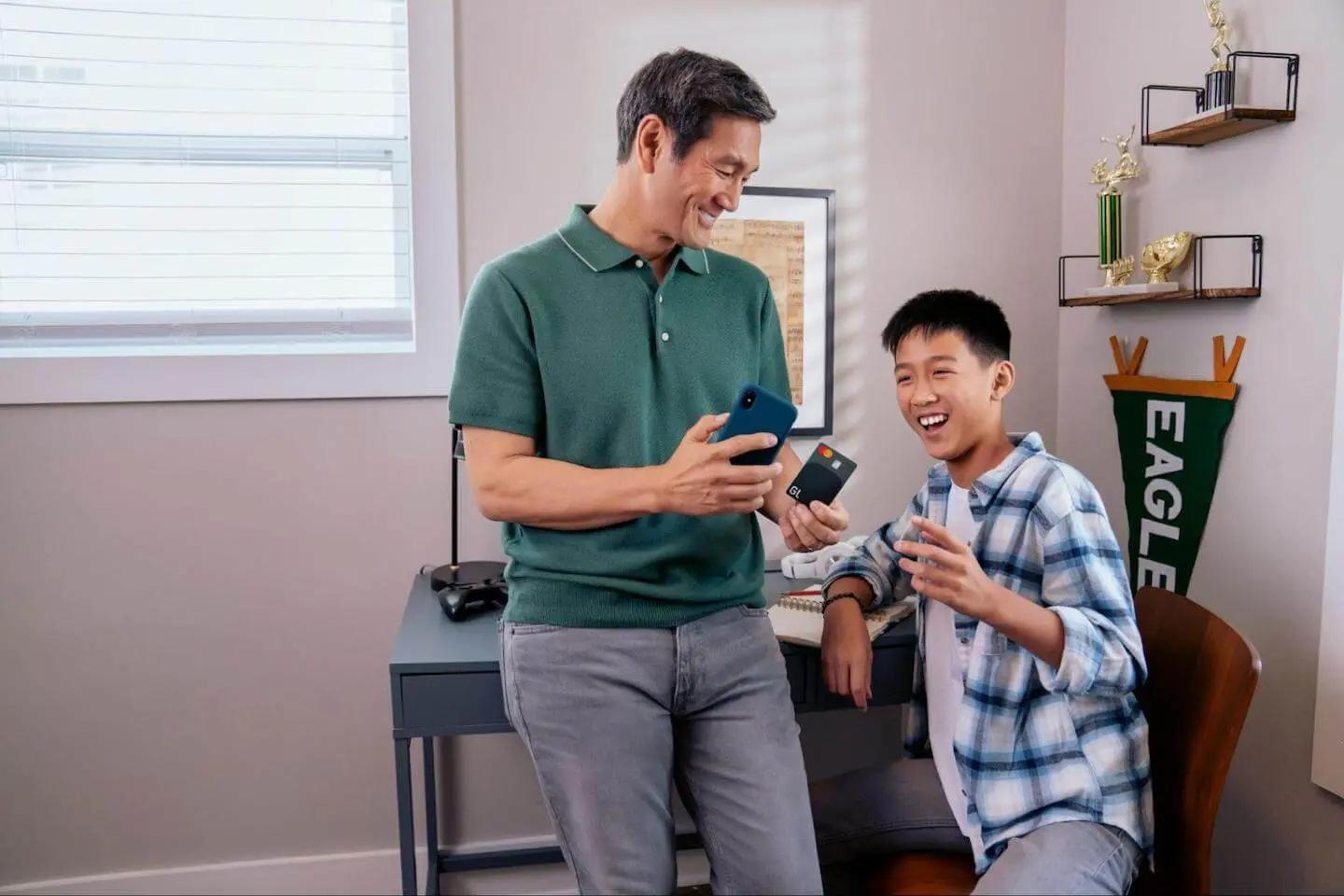 How to increase your credit limit: father teaching his son how to shop online using a credit card