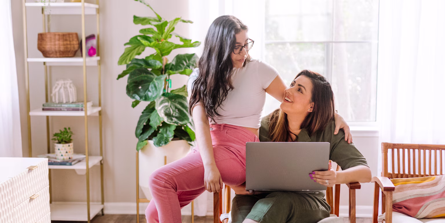 Mom and daughter chatting in living room about safety when using internet devices