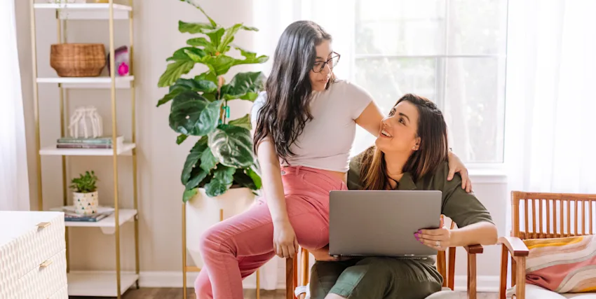 Mom and daughter chatting in living room about safety when using internet devices