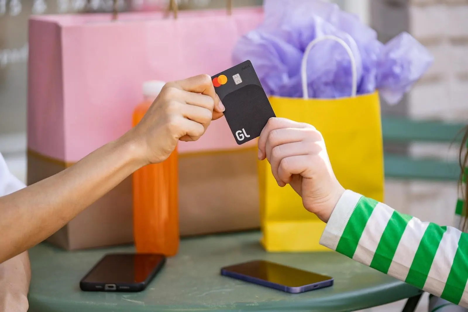 A closeup of two people handing off a debit card