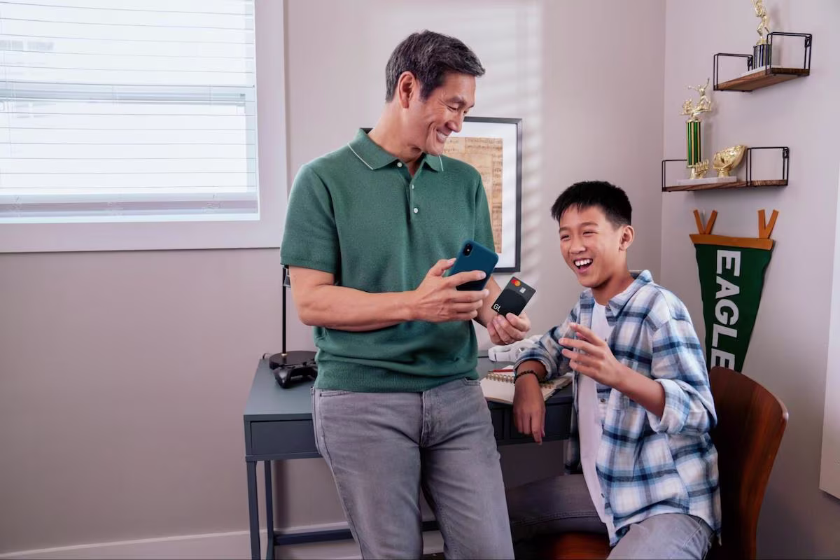 Father showing his credit card to his son