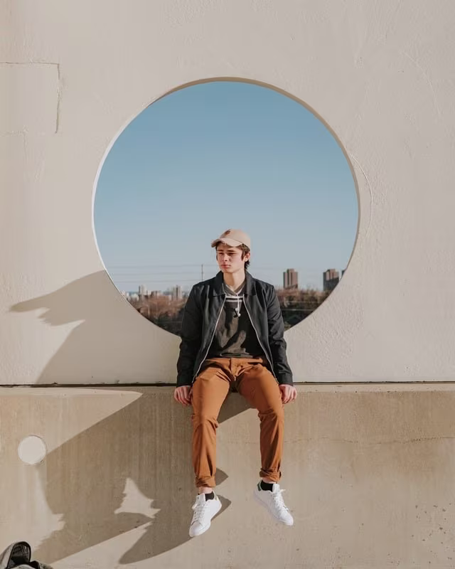 Teen sitting on cement wall