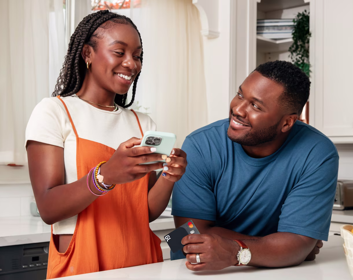 Father and daughter in the kitchen with cellphone and card in hand