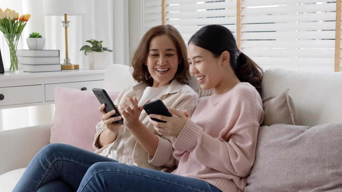 Mother and daughter checking a mobile kids investing app together