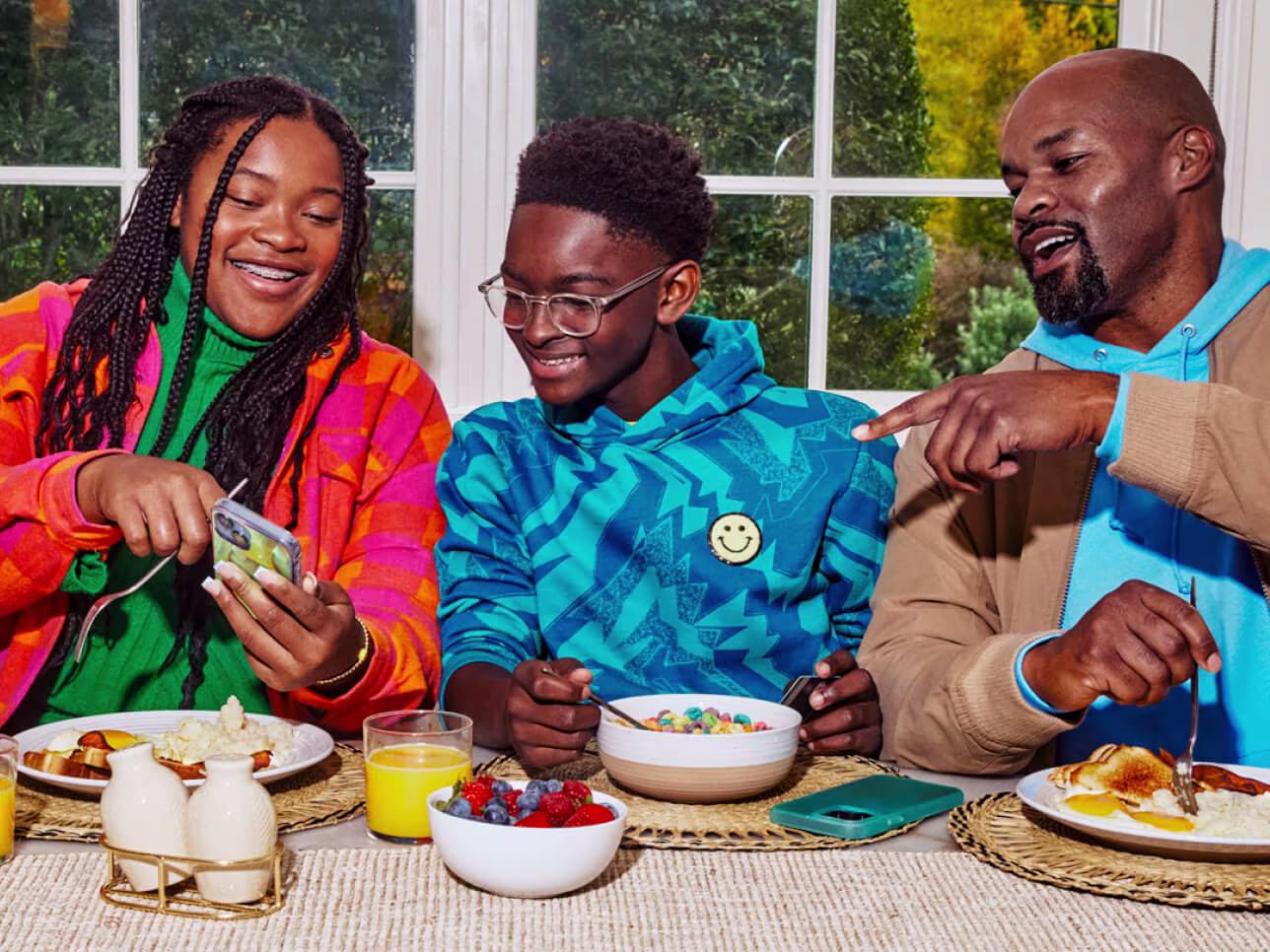 Family gathered around table taking a breakfast.