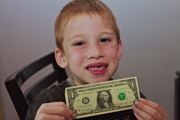 kid holding a dollar bill