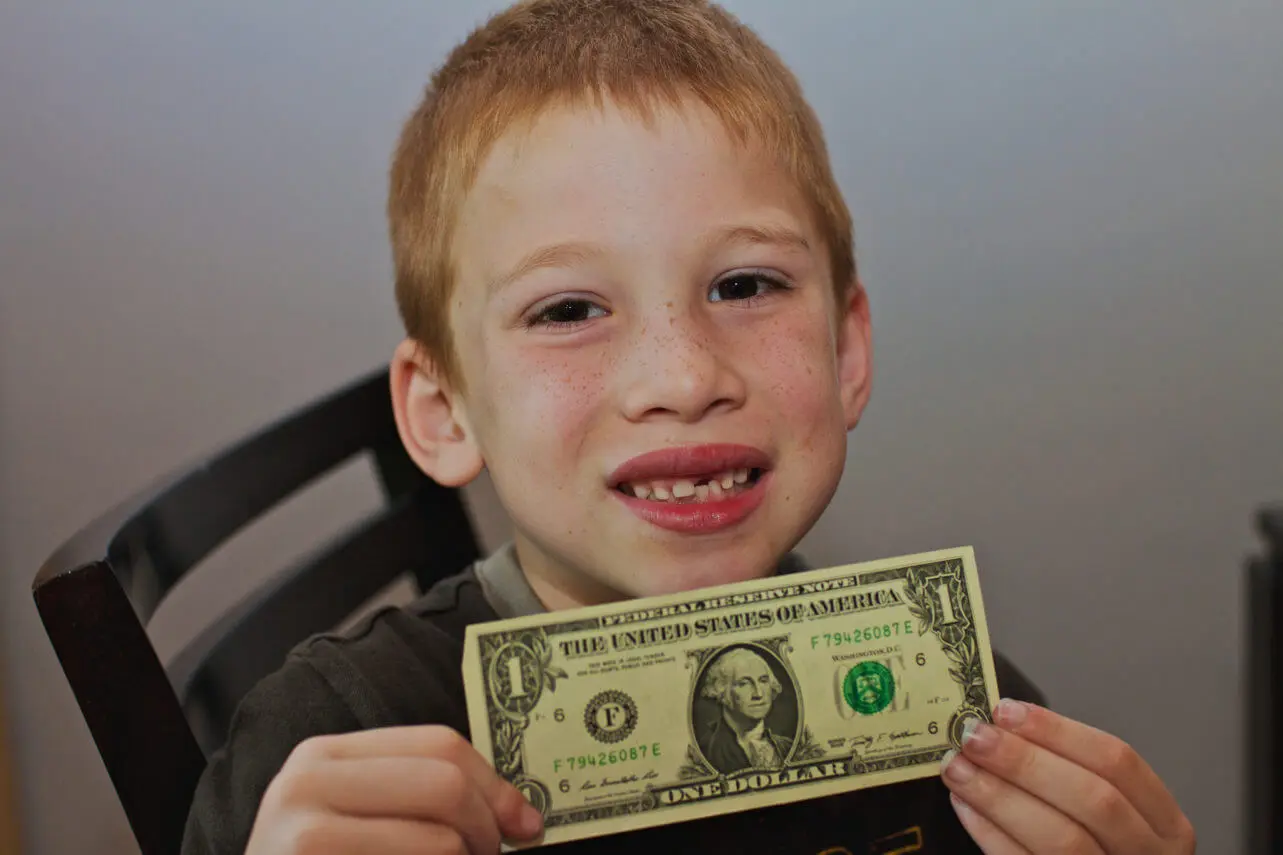 kid holding a dollar bill