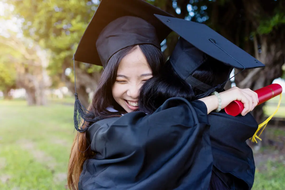 Graduates happily hugging each other