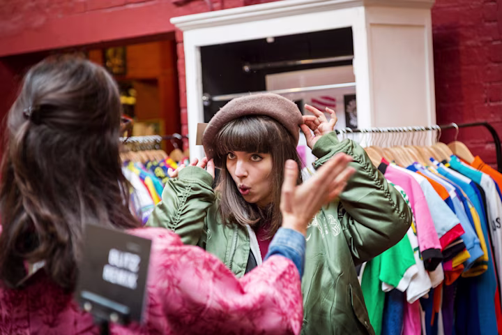 Two girls trying on clothes at a store.