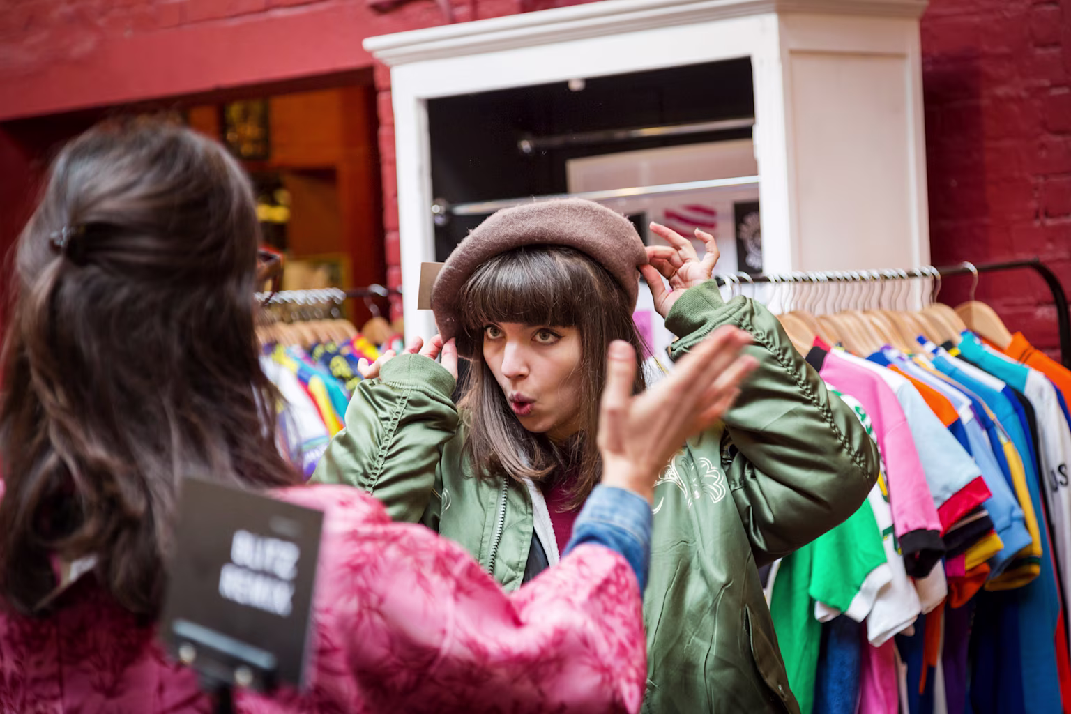 Two girls trying on clothes at a store.