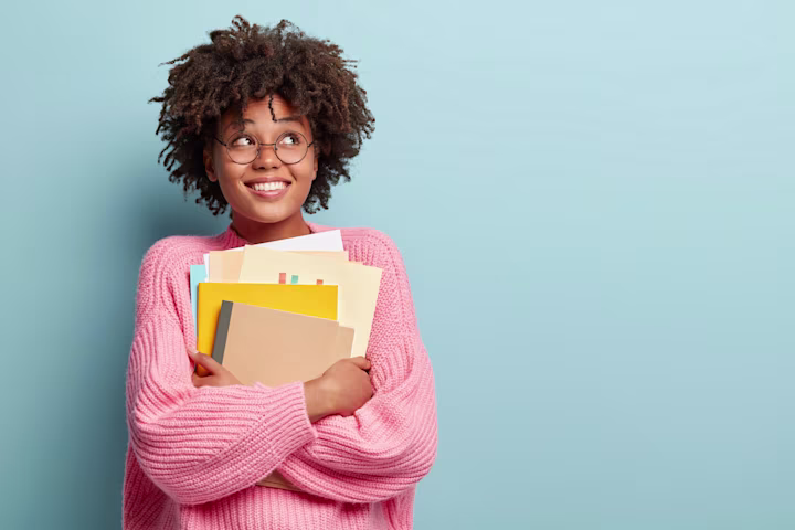 student carrying some books and folders
