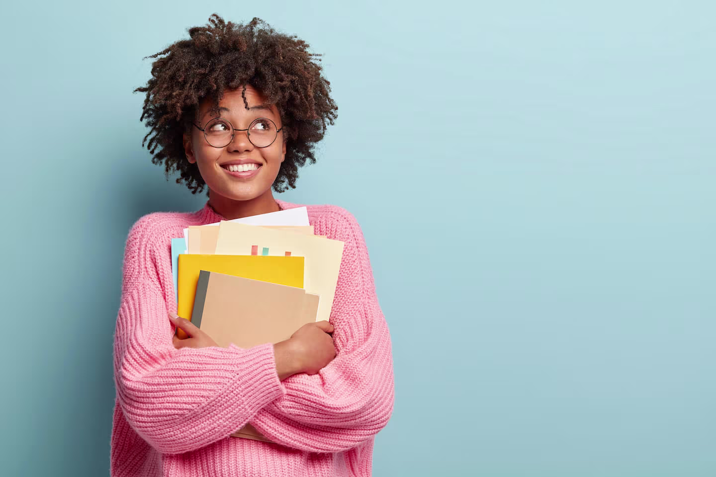 student carrying some books and folders