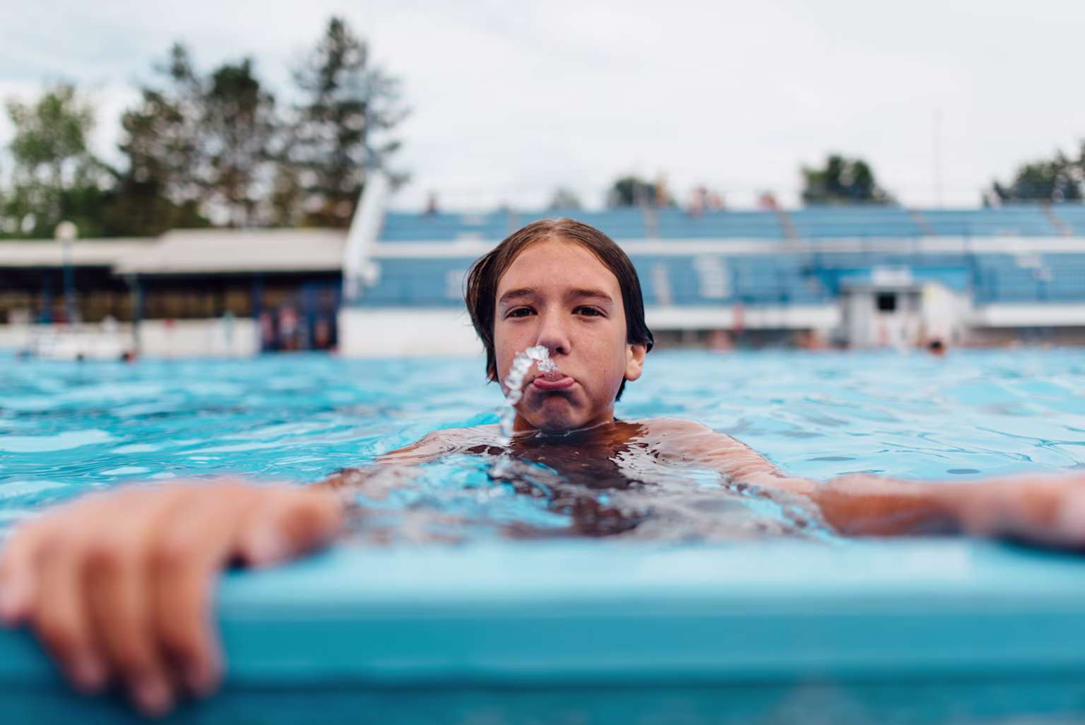 A boy swimming in a swimming pool.