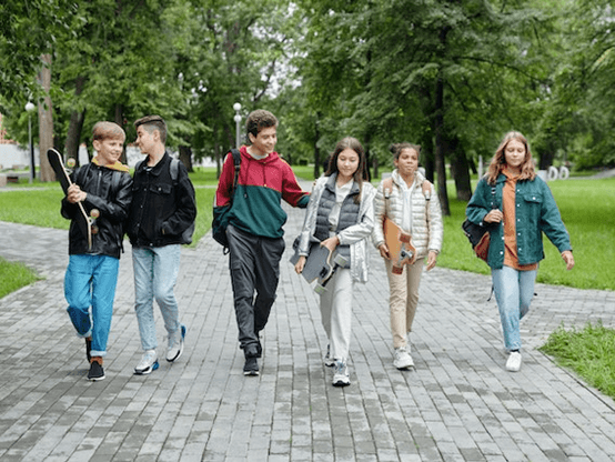 A group of kids walking down a park path.
